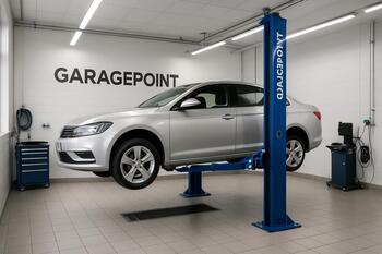 Neon işıqlı GaragePoint boksunda qaldırıcıda yoxlanılan avtomobil